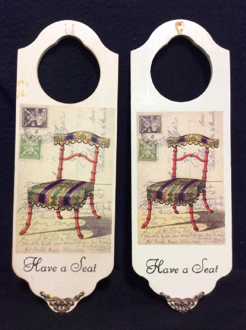 Pair Door Knob Hanging Plaques: Pair Door Knob Hanging Plaques. Each feature print of chair illustration and read ‘Have a Seat’. Some minor surface wear. Home decor, home accessories. Measures approx 12 in tall by 4 in wide.