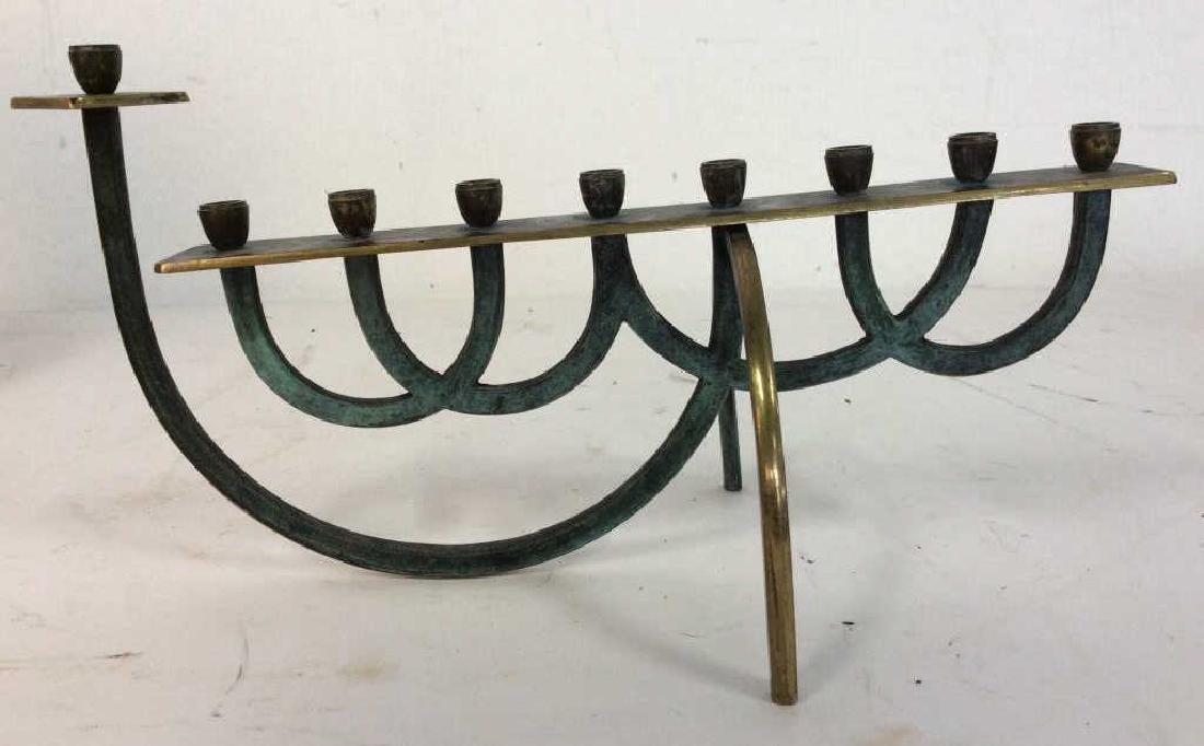 Green & Gold Toned Judaica Menorah: Menorah is metal, contains tones of green and gold. Contains c curve detail. Measures approx 12 inches long 6.5 inches tall. Jewish ceramonial tableware,