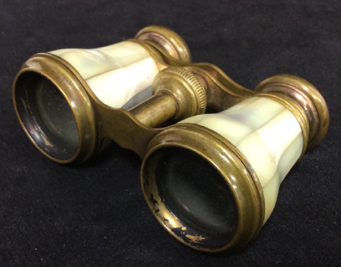 Vintage Mother Of Pearl Opera Glasses: Contains tones of cream and gold. Right eyepiece has loose eyeglass piece. Metal portions appear to be brass. Measures approx 4 inches long 2.75 inches deep.