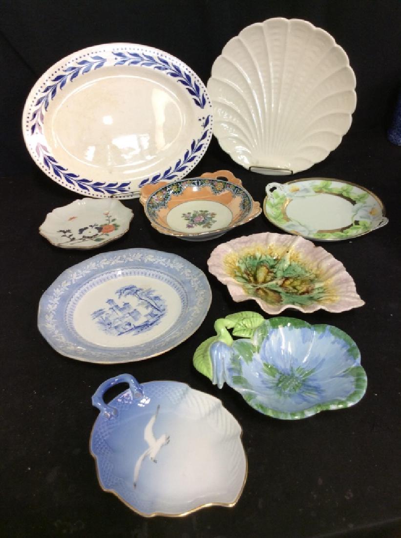 Group Lot 9 Porcelain Plates: Group Lot 9 Porcelain Plates, platters, centerpieces. Various brands including KJOBENHAVN, NORITAKE, and more. Some surface wear including rim chips and wear to paint on some pieces. Decorative tablew