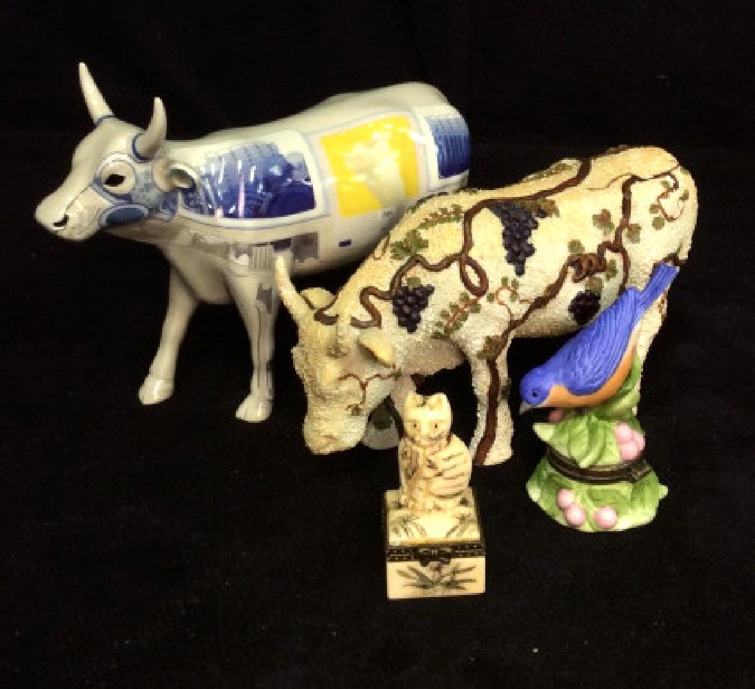 Lot 4 Animal Figurals: Statuette Group containing two cow figures 1 blue bird pill box and 1 cat pill box, various materials, composite porcelain, faux bone, bird pill box underside marked PHB limited collection, cow figura