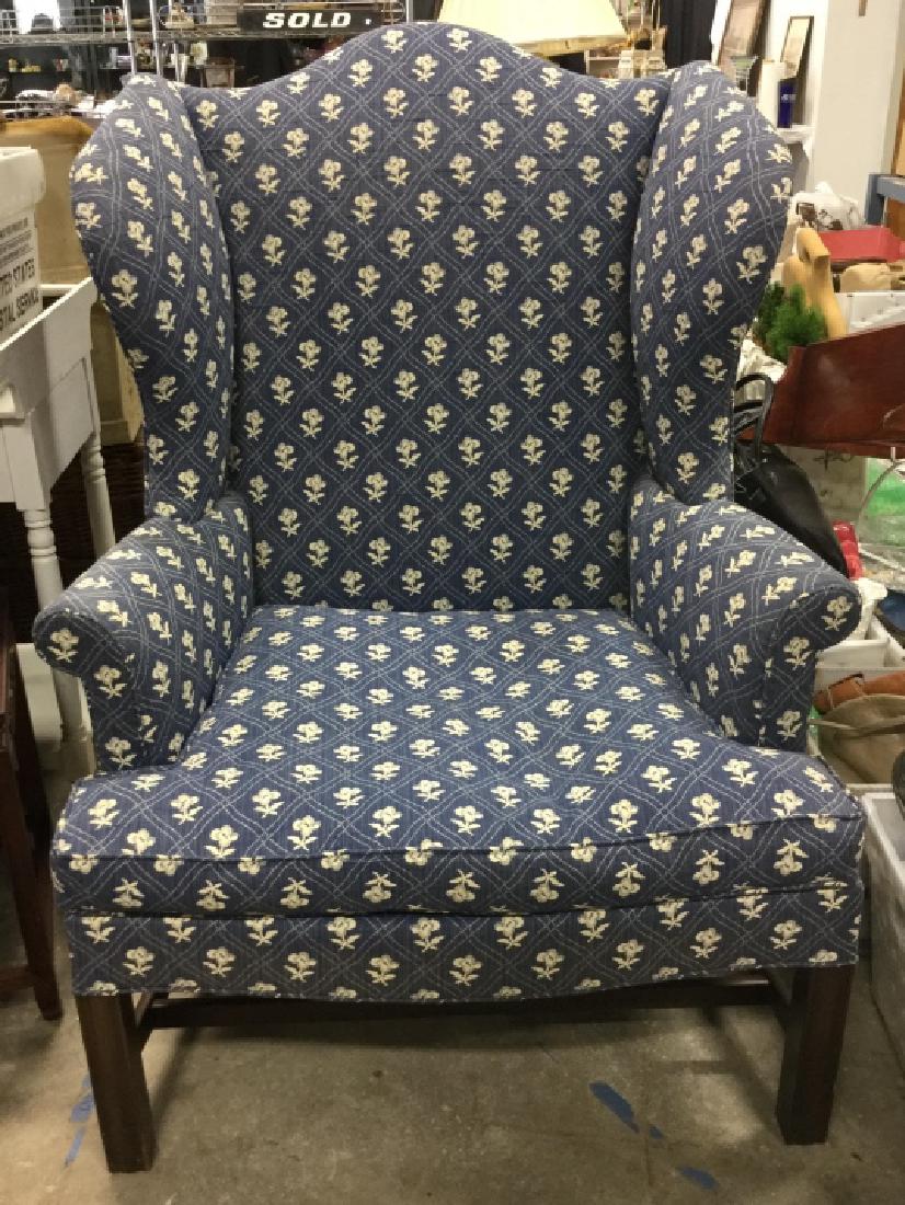 KITTINGER Upholstered Blue Toned Wing Chair: Wing chair has a blue tone with cream toned patterned floral detail. Seat cushion is loose. Tag underneath cushion reads KITTINGER. Piece has brown toned wooden legs. Upholstery has some stains and we