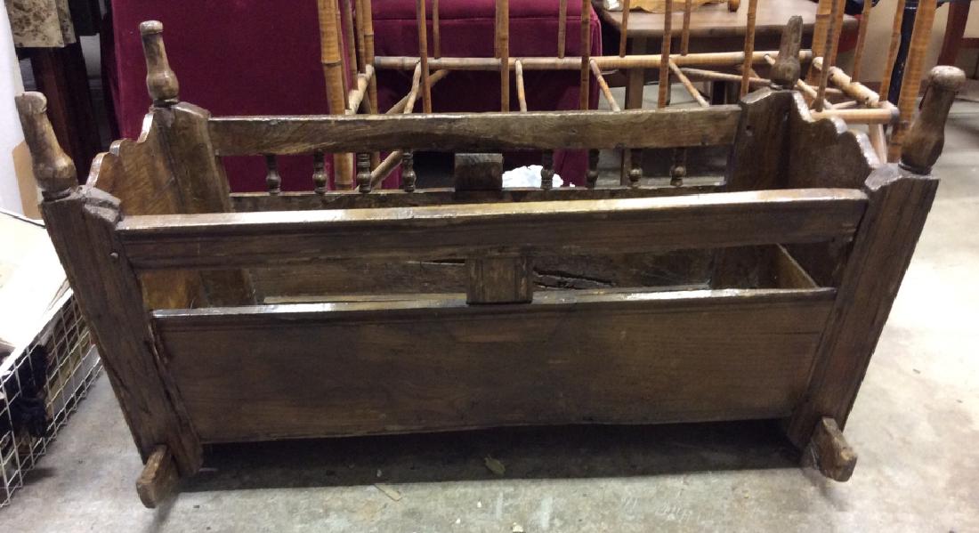 Antique Carved Wooden Rocking Cradle: Crib is vintage possibly antique. Contains carved wooden detail. Contains evident wear chips & cracks due to age. Measures approx 37 inches long 21 inches deep 21 inches tall. Rocking cradle, baby fur