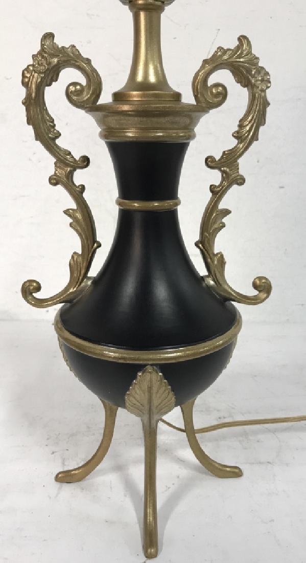 Black & Gold Toned Metal Lamp: Lamp is black & gold toned. Has toned legs and ornate detailed handles with c curve detail. Measures approx 18.5 inches tall 8 inches wide without shade. Home decor, home accessory, home lighting.