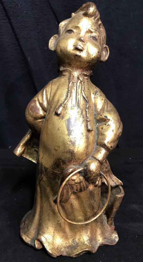 Gold Toned Composite Sculpture Of Child: Sculpture is gold toned. Contains evident wear and scratches. Measures approx 13 inches tall 7 inches wide and deep. Decorative home accessory, statuary, home decor.