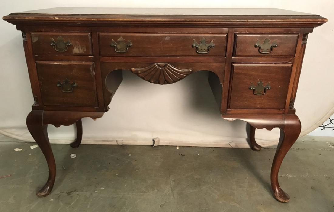 Vintage Carved Wooden Executive Desk: Desk is vintage. Contains 5 drawers. Each with metal handles. Contains carved wooden feet. Piece has evident scratches & surface chips. Measures approx 42 inches long 30 inches tall 18 inches deep. Dr
