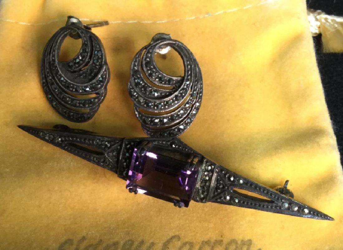 Art Deco Jewelry Set, Paris: Art Deco pin brooch with marcasite detailing and purple Amethyst Center stone, emerald cut Stone Measures app .5 by.25 inches, length of pin app 2.5 inches, comes with coordinating Art Deco Earrings w