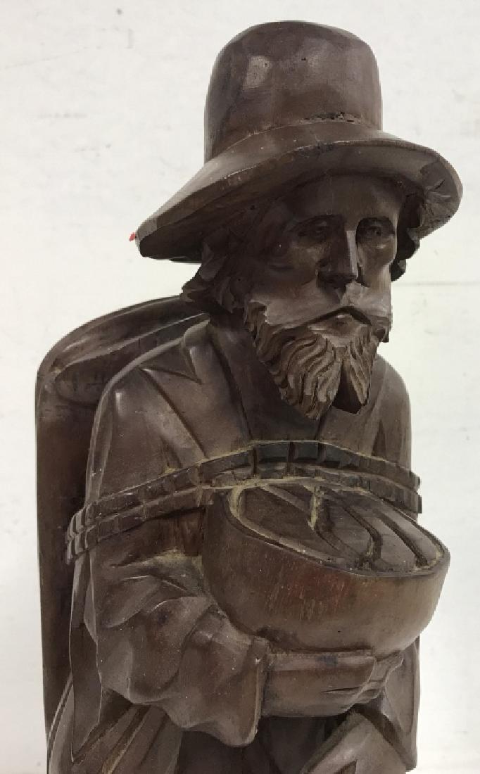 Vintage Carved Wooden Figure: Vintage Carved Wooden Figure of a bearded barefooted Man walking with a cane and a satchel on his back, accompanied by a small dog at his heel, 23 in tall x 8 in at the base, possibly carved from one