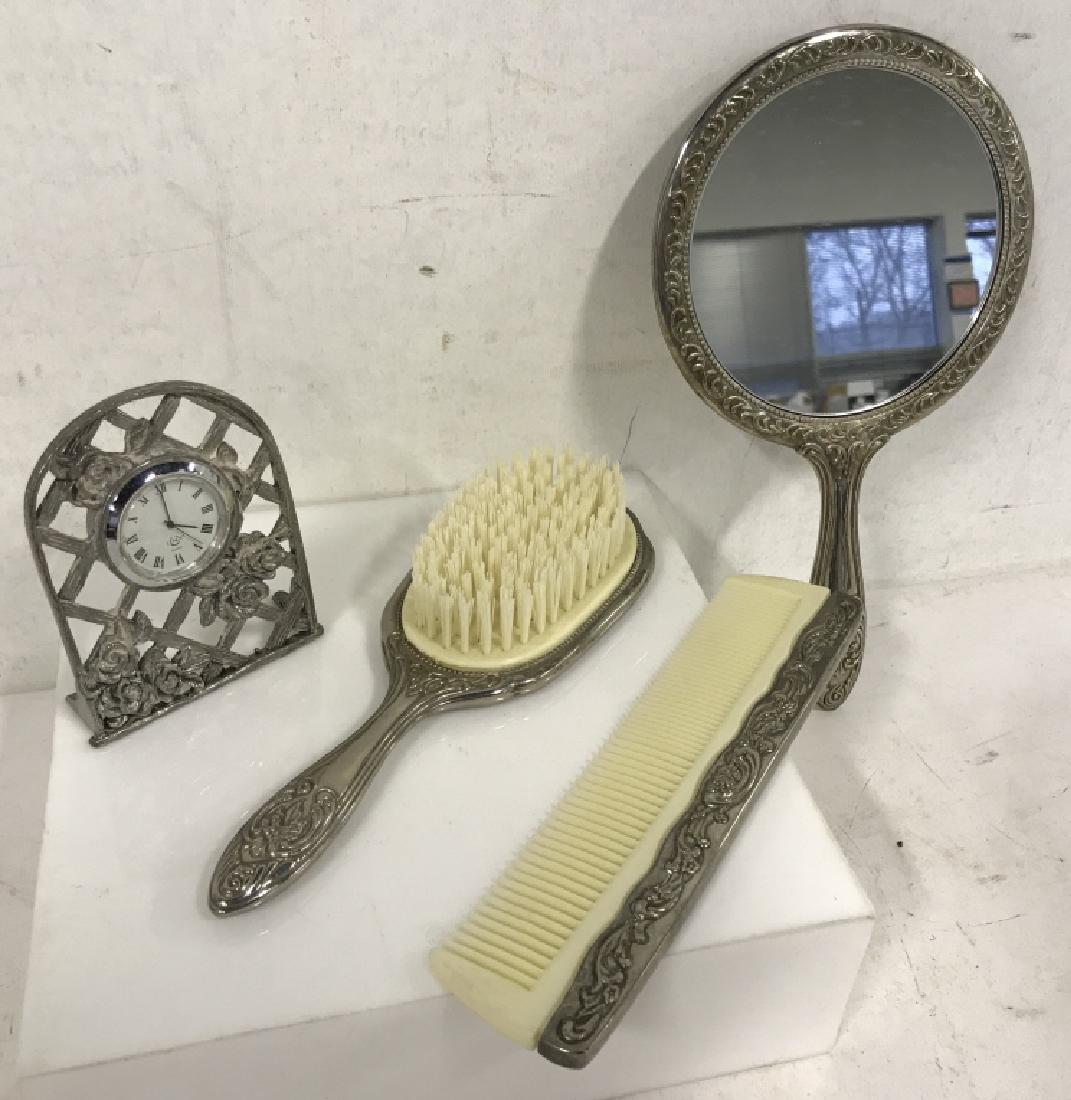 Group of 4 Vintage Silver Toned Vanity Accessories: Group of 4 vintage vanity accessories. Accessories include: hand mirror, comb, brush, and tabletop clock. All accessories have silver toned metal frames. Small tabletop clock is labeled LENOX quartz c