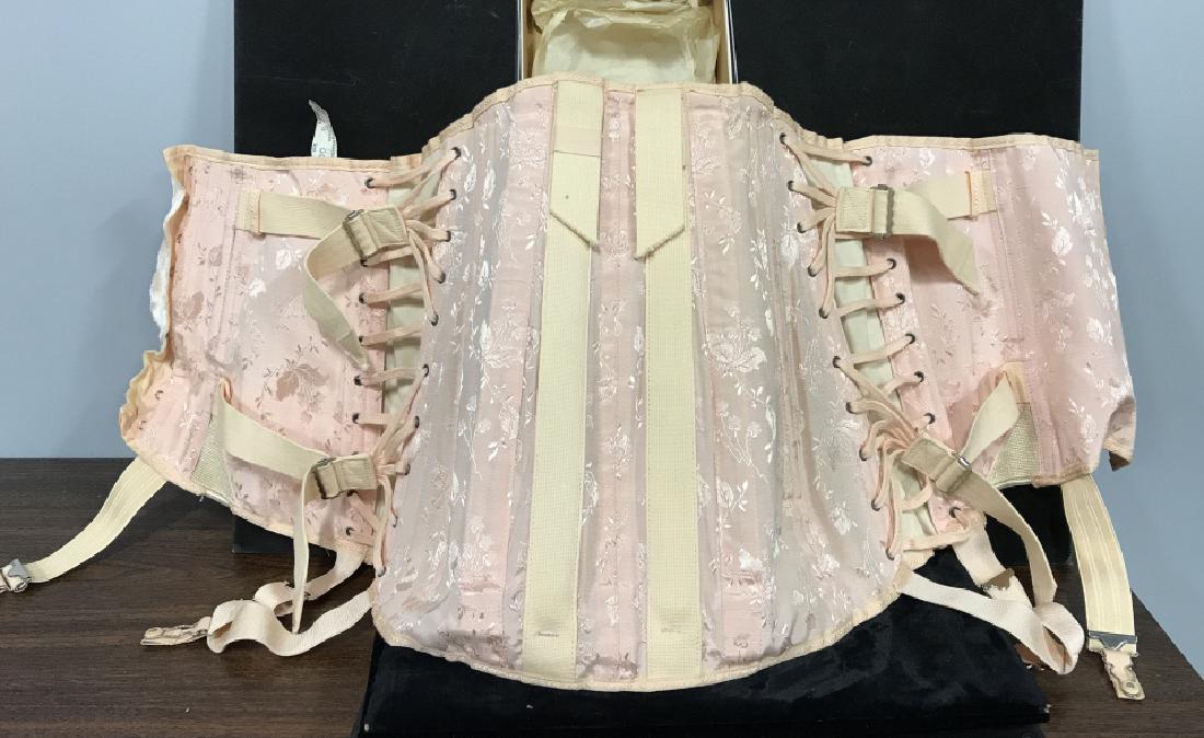 Vintage Ladies Corset in original Box: Vintage Ladies Corset in original American Silver Truss Corp., date on Box 9-10-‘58, pink fabric, with boning and laces and hook and eye closure, also with garter snaps, measures 34 inches at widest