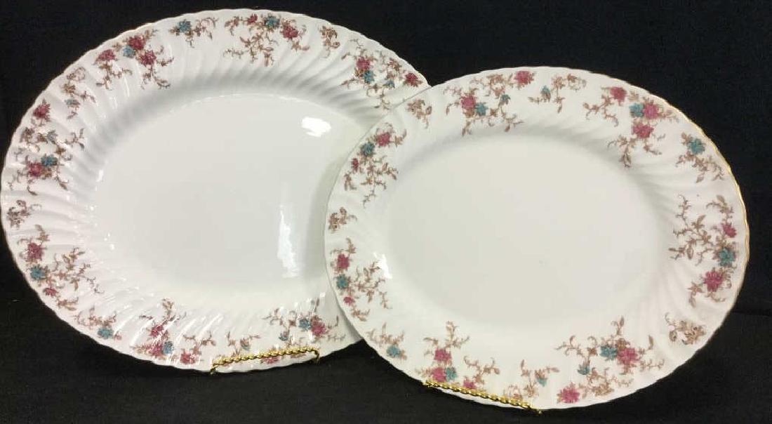 Pair of MINTON Bone China Oval Serving Platters: Pair of MINTON Bone China Oval Serving Platters / Dishes. Platters are white in tone with floral blue / purple / brown tone patterned print along borders. Gold tone trim along rims. Some minor fading 