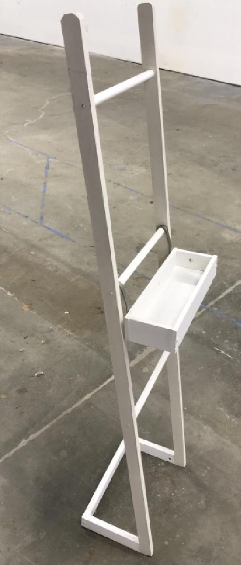 White Tone Wooden Standing Shelf Easel: White tone wooden standing shelf. Artists Easel, Shelf hooks onto ladder - like structure and can be moved from prong to prong to adjust height. Structure is light in weight. Approx 60 inches in heigh