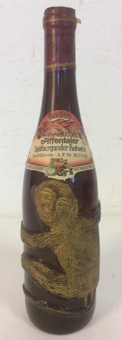 Bottle of SPATBURGUNDER 1982 Red Wine: Bottle of SPATBURGUNDER 1982 bottle of red wine with bronzed hugging monkey in relief on bottle. Bottle is unopened, and original labels still in place and in good condition. Bottle approx 12.5 inches