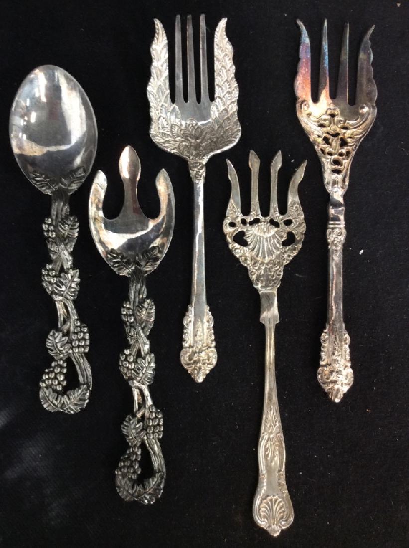 Lot 5 Silver Toned Metal Serving Utensils: Lot 5 Silver Toned Metal Serving Utensils. Decorated with raised intricate fruit and filigree designs, some surface wear and discoloring. Measures approx 11 in long. Serving Utensils, Flatware, tablew