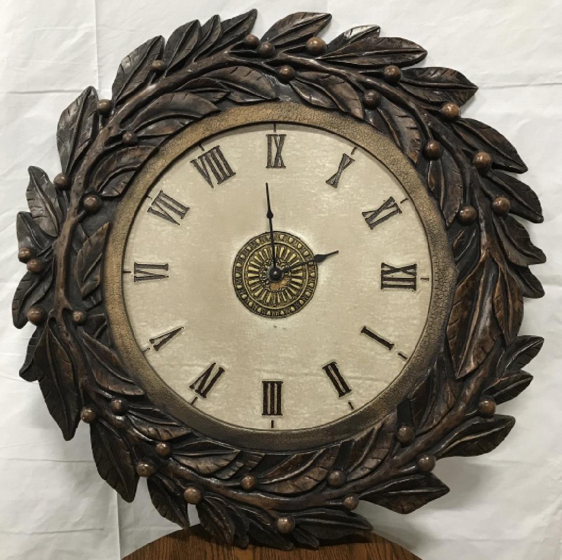 Faux Carved Wooden Wall Clock W Roman Nemerals: Faux Carved Wooden Wall Clock W Roman Nemerals. Clock not tested. Measures approx 31 inches in diameter. No condition issues noted. Wall Clocks, wall decor, home accessory, decorative accessory. 2