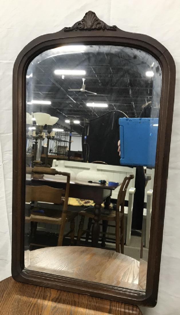 Antique Wooden Wall Mirror W Carved Design: Antique Wooden Wall Mirror W Carved Scroll Design at top and beveled interior mirror. Small chip to top of carved design and some chips at edges. Measures approx 32 inches tall x 18 inches wide. Wall 