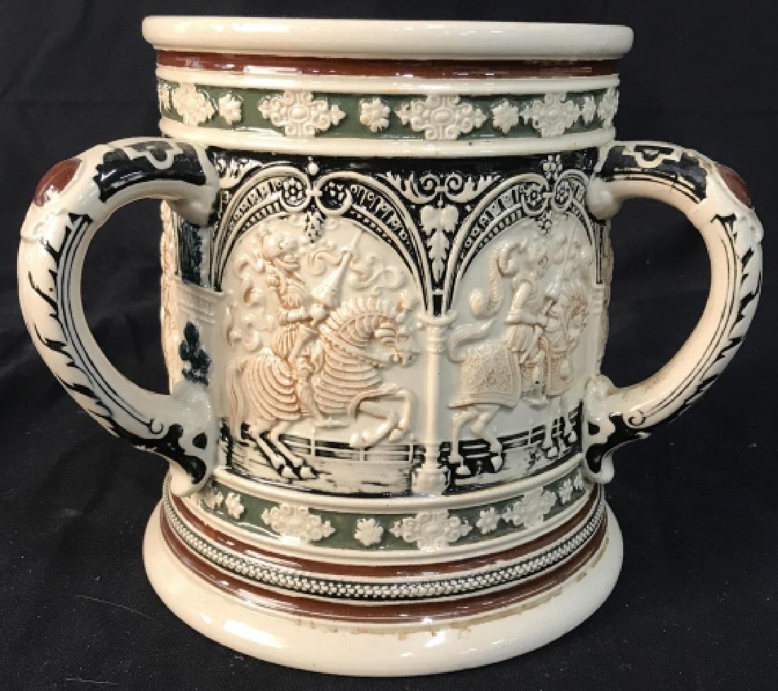 German Oversized Ceramic Tankard: Tankard, with three handles, relief scenes of warriors on horseback, measures ht 7 inches Handle to handle diameter app 8.5 inches, tableware, accessory, up cycle vase, planter, cache Pot, made in Ger