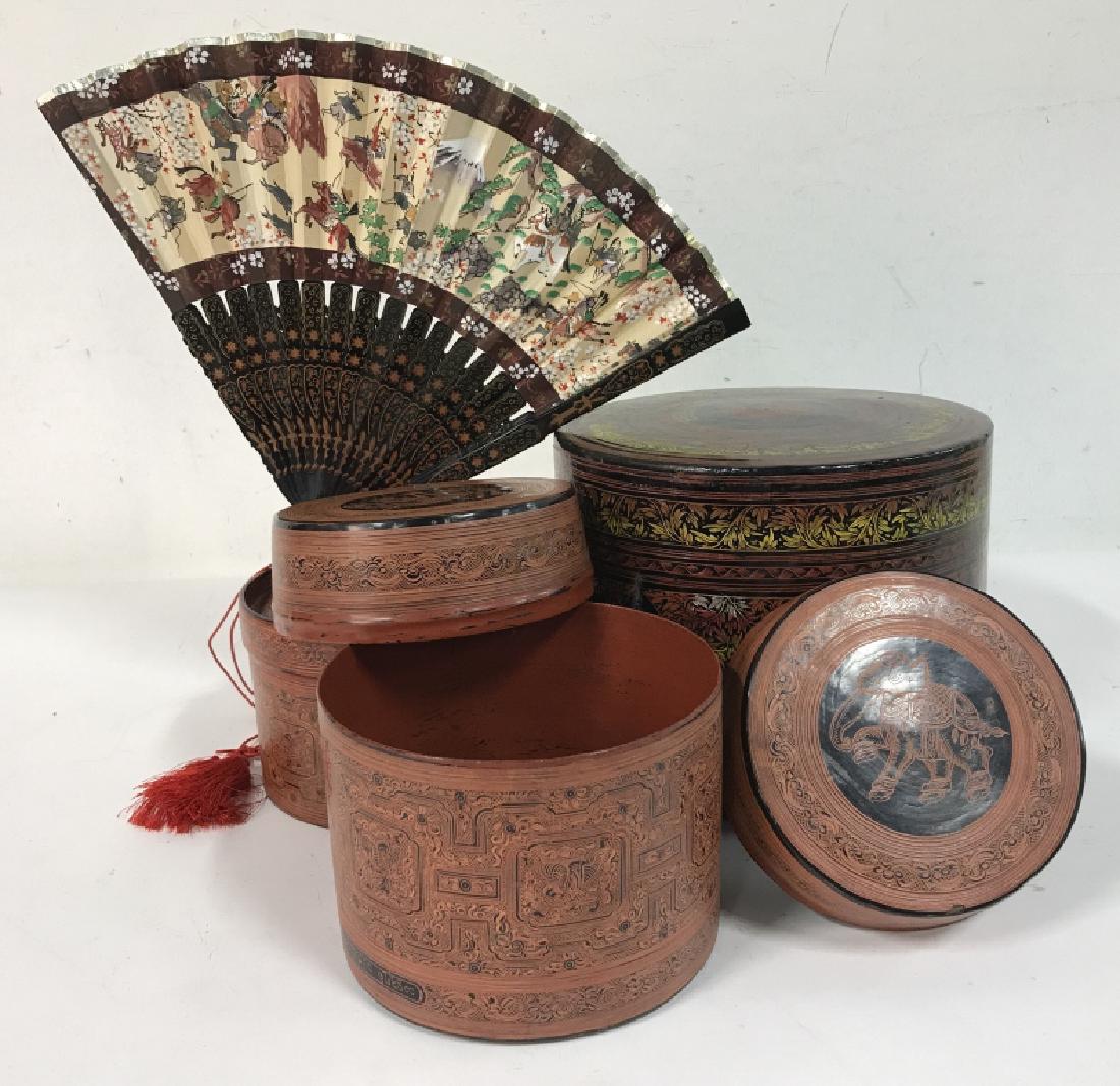 Group of Decorative Indonesian Boxes with Fan: Group of decorative Asian or Indonesian Colorfully Painted in black and red and gold, decorated with images of animal symbols, largest measuring 7 in high x 8 in diameter, fan depicts colorful figures