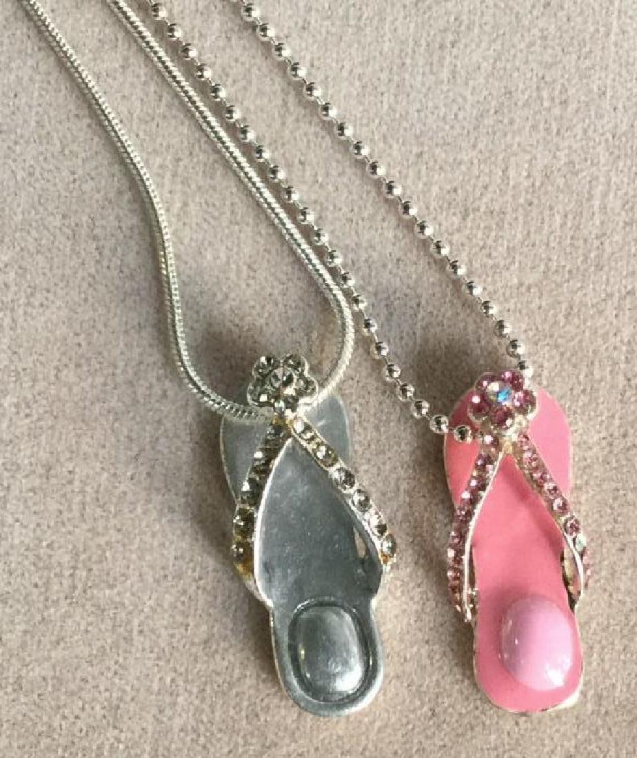 Pair of Sandal / Flip Flop Charm Necklaces: Pair of sandal / flip flop charm necklaces. Necklaces are silver Toned. Flip flop charms are pink and silver in tone. Two rhinestones missing from pink sandal charm. Vintage Jewelry, statement necklac