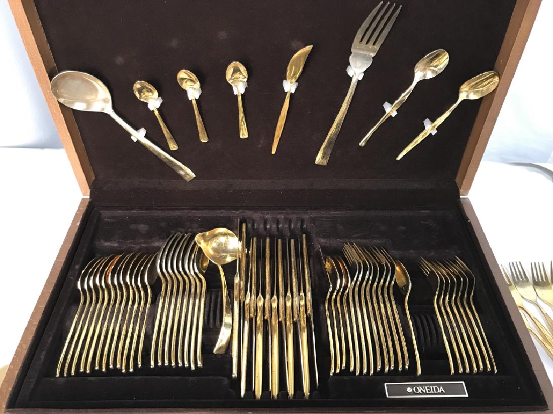Group Lot of Gold Toned Oneida Flatware: Group Lot of Gold Tone Oneida Flatware, Cosmos Pattern, in original box including 16 teaspoons, 8 tablespoons, 1 soup Ladle, 12 dinner knives, 8 Dinner forks, 7 salad forks, also included Set of Stanl