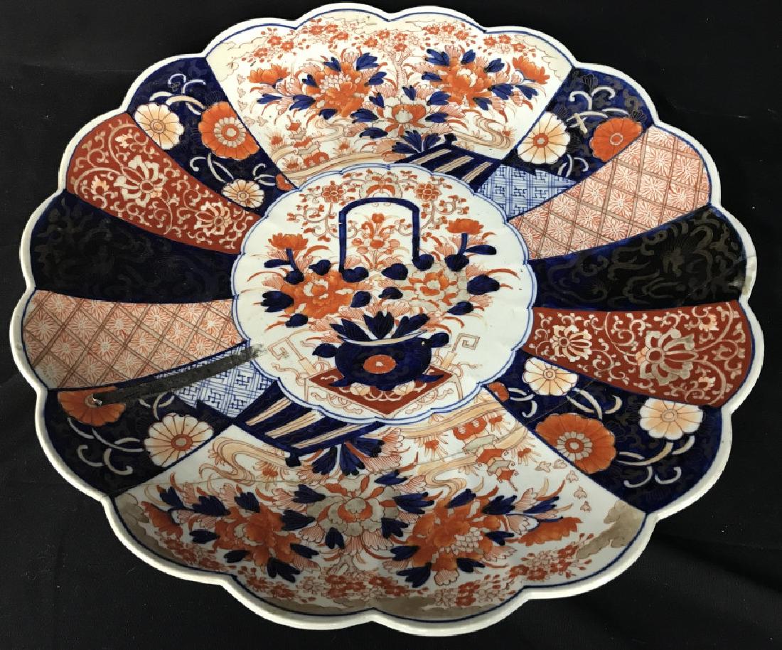 IMARI Floral Shaped Oriental Porcelain Platter: Platter is floral shaped with tones of blue, red, white, & orange. Contains various, floral, leaf & vine patterned details. Has been repaired. Measures approx 18 inches wide. Tableware, tabletop acces