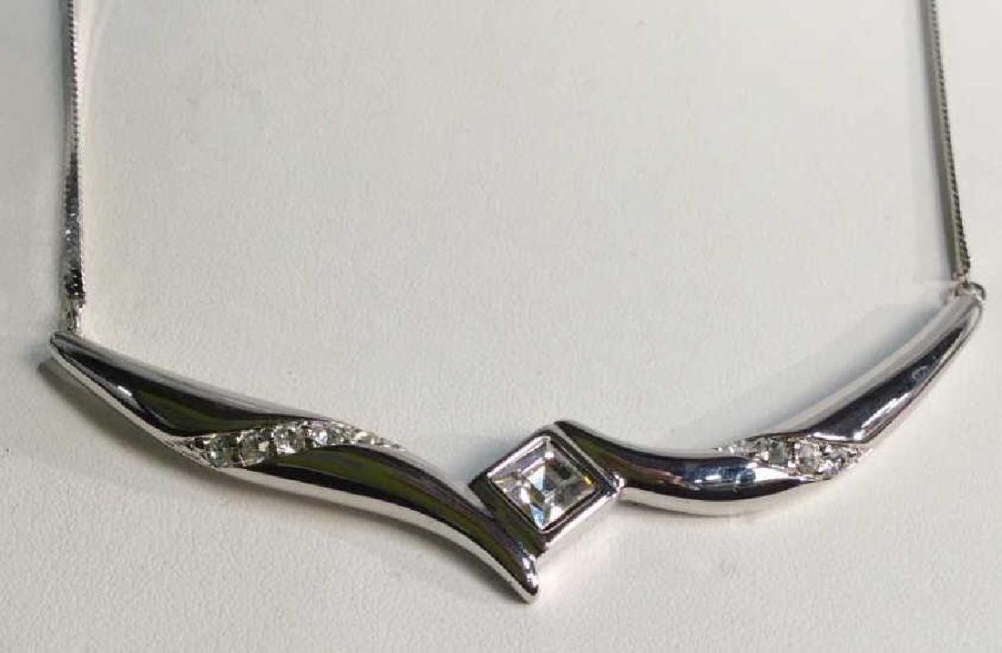 Silver Toned Necklace W Rhinestone Pendant: Silver toned necklace with rhinestone pendant. Vintage Jewelry, statement necklace, costume jewelry. Marked Monet on underside of pendant. Drop length of necklace strand measures approx 7 inches. Esta
