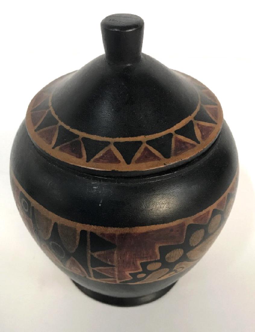 Painted Wooden Jar & Lid: Jar is wooden. Contains tones of red, orange and black. Jar includes lid. Measures approx 5.5 inches tall 4 inches wide. Tableware, tabletop accessory, wooden accessory 6.