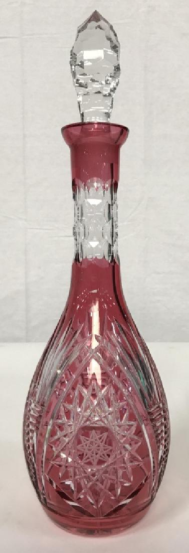 Cranberry Glass Crystal Cut To Clear Decanter: Cranberry Glass Crystal Cut To Clear Decanter. A cranberry crystal glass decanter with cut Brunswick star and line design. Includes stopper with cut design. Measures approx 16 inches tall x 4.75 inche