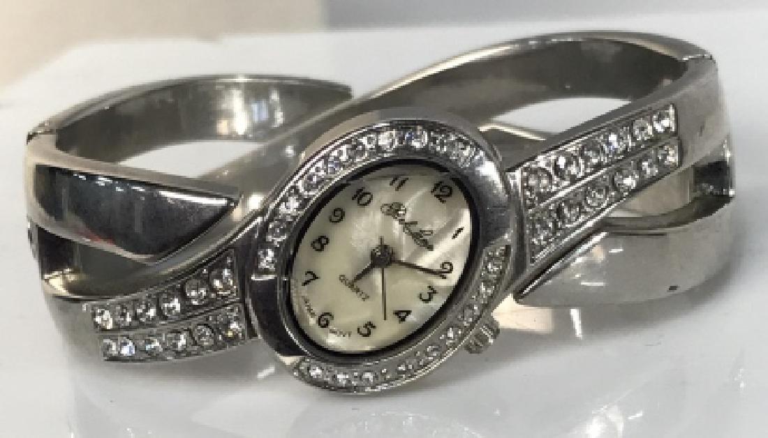 Vintage Park Lane Ladies white gold Toned watch: Vintage Park Lane Ladies white gold Toned watch, oval mother of pearl face, handle band with invisible clasp, pave set rim of face, not tested, back of face marked stainless steel, 2 1/2 in wrist diam