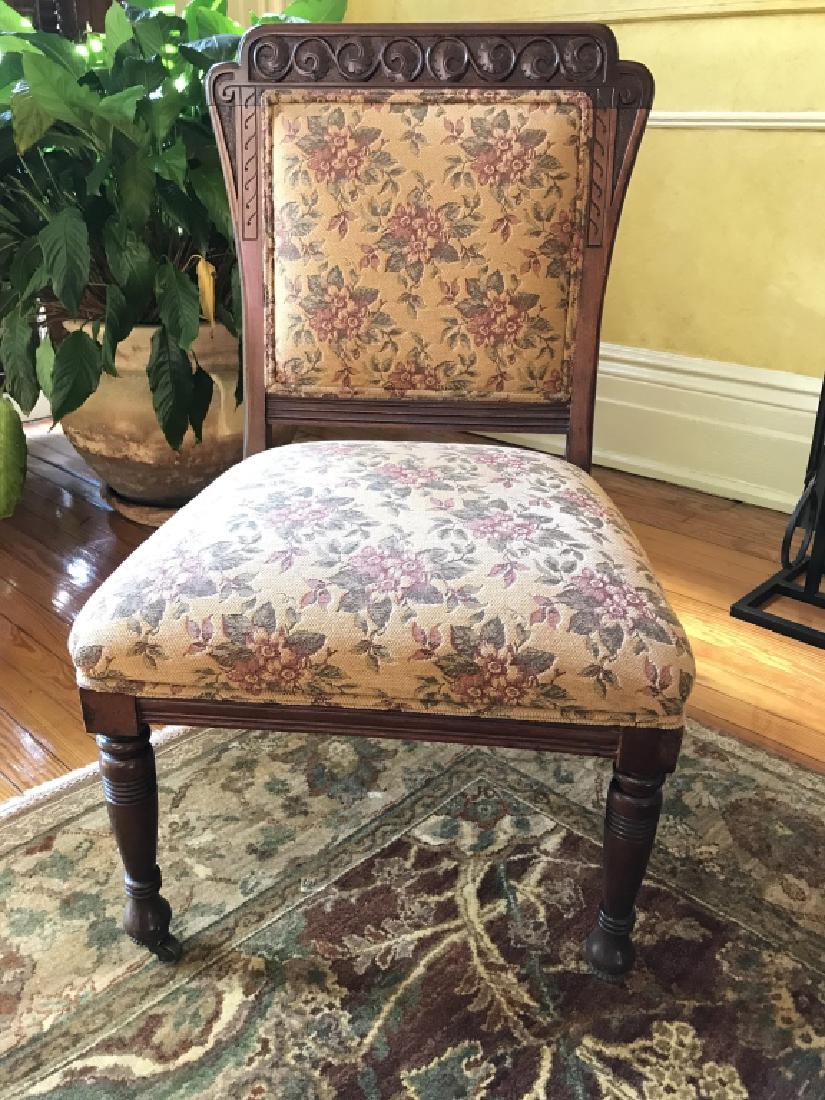 Vintage Hand Carved Upholstered Side Chair: Vintage poss antique hand carved Upholstered Side Chair, Carved Scrolled leaf motif at top, turned front legs, caster feet, and upholstered seat and back in pink, green, and beige floral and leaf desi