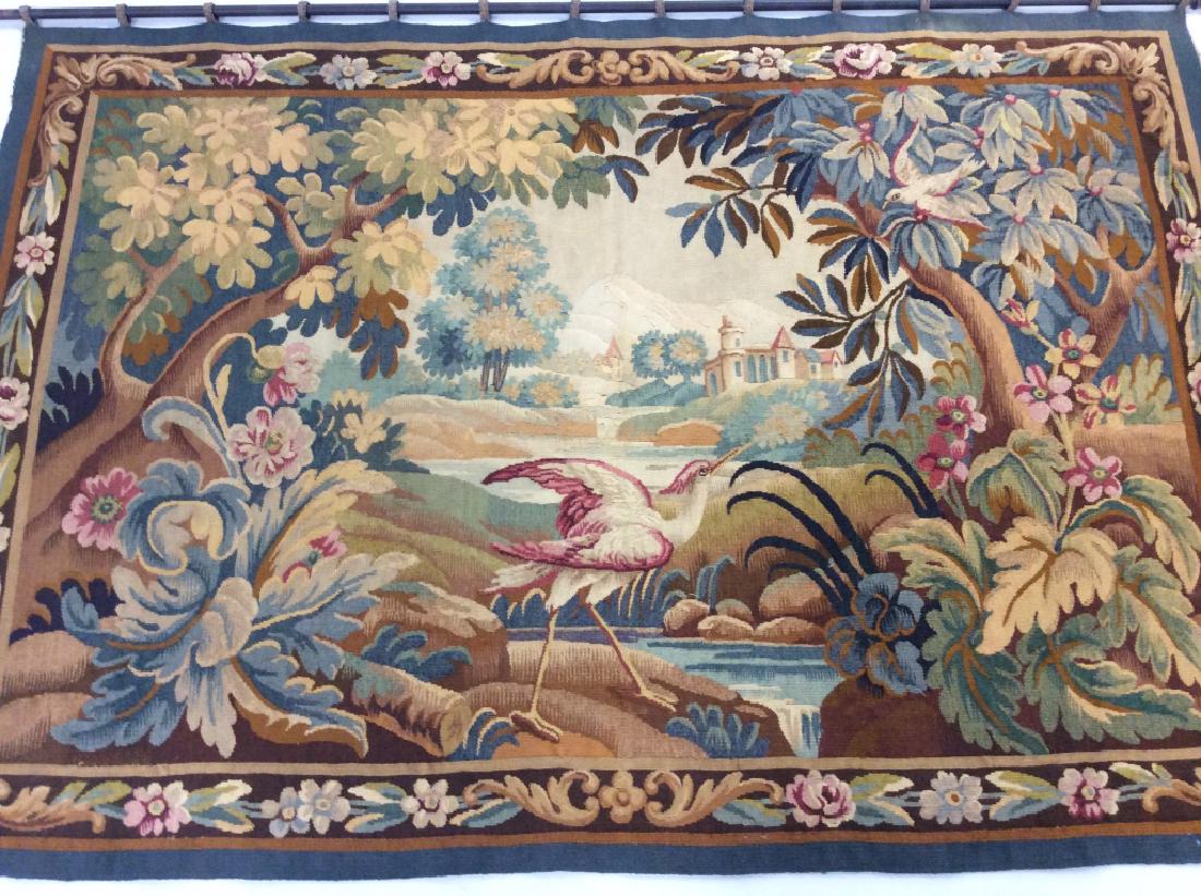 C. 1920s French Handmade Verdure Tapestry: C. 1920s French handmade verdure tapestry in the style of Aubusson. Tapestry is woven wool possibly with woven silk highlights / details. Tapestry depicts a crane in a wooded scene, with a town among 