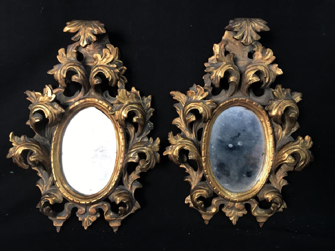 Pair Rococo Style Carved Giltwood Mirrors: Pair of possibly antique Rococo Style carved giltwood framed wall mirrors with stylized scrolled acanthus leaf motif. Measure approx. 11.5 inches tall x 8.5 inches wide x 2 inches deep. Requires light