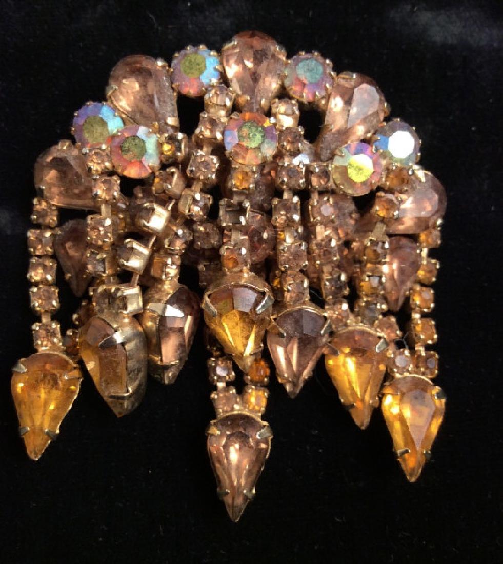 Topaz Toned Rhinestone Brooch Pin: Topaz Toned Rhinestone Brooch Pin. Gold Toned w Rhinestones. Layered brooch pin with strands of round cut and tear drop cut rhinestones, some cleaning may be required. Measures Approx 2 1/2 in by 2 1/