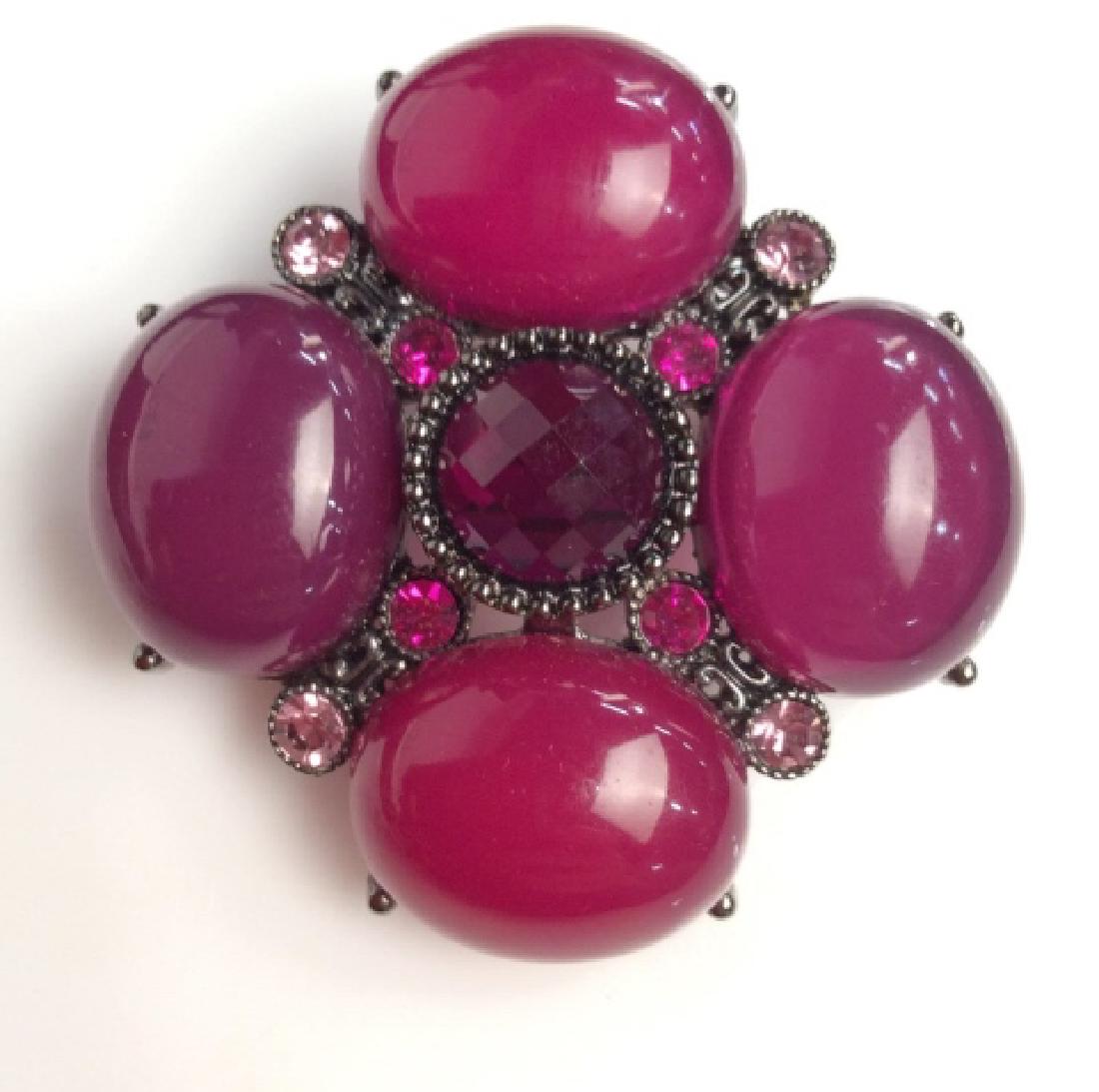 Plum toned Rhinestone Brooch Pin: Plum toned Rhinestone Brooch Pin. Dark purple toned Rhinestone center framed with smaller pink toned rhinestones and large purple toned cabochon style composite beads. Has loop to Ben worn as pendant.