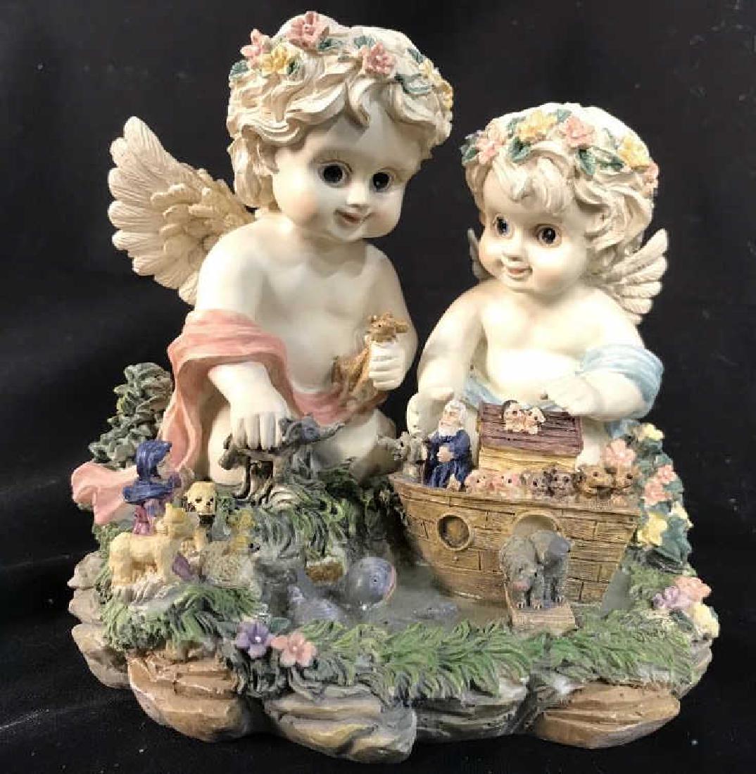 SANKYO Cherub Detailed Composite Music Box: Music box depicts 2 cherubs loading Noah’s arc with animals. Measures approx 7 inches long 6 inches tall & deep. Contains some minor chips. Cherubs, puttis, angels, 6.