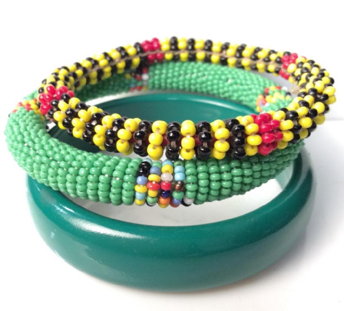 Lot 3 Women’s Vintage Costume Jewelry Bracelets: Lot 3 Women’s Vintage Costume Jewelry Bracelets. Two beaded bracelet with tones of green, black, yellow and reds, one bangle composite material green toned bracelet. Measures approx 3 in in diameter