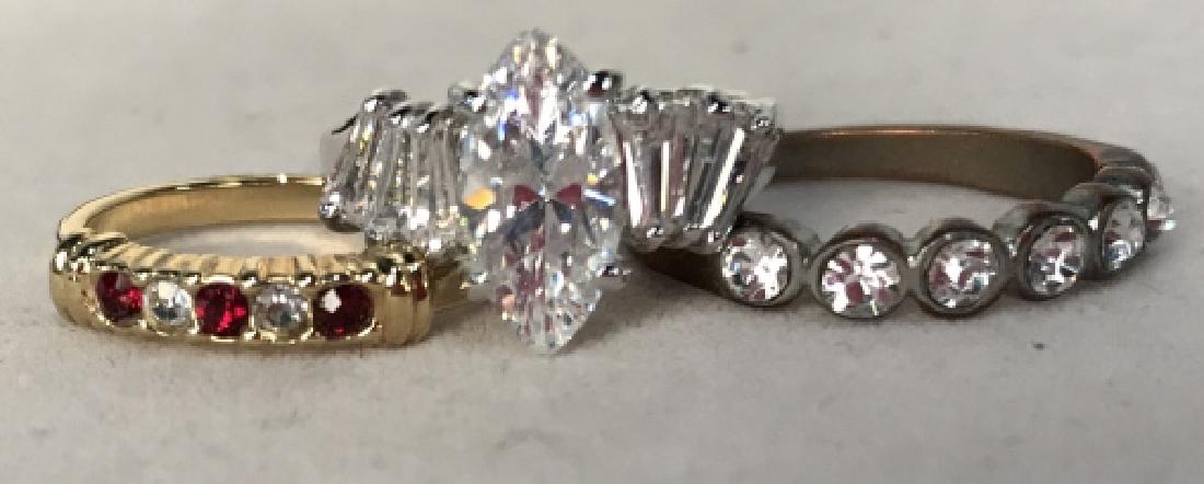 Group Lot of Wedding Engagement bands: Group Lot of wedding bands, two half set with red and white rhinestones, 1 solitaire flanked with banquettes in a silver toned setting, good condition, Largest measures approx size 8, solitaire approx