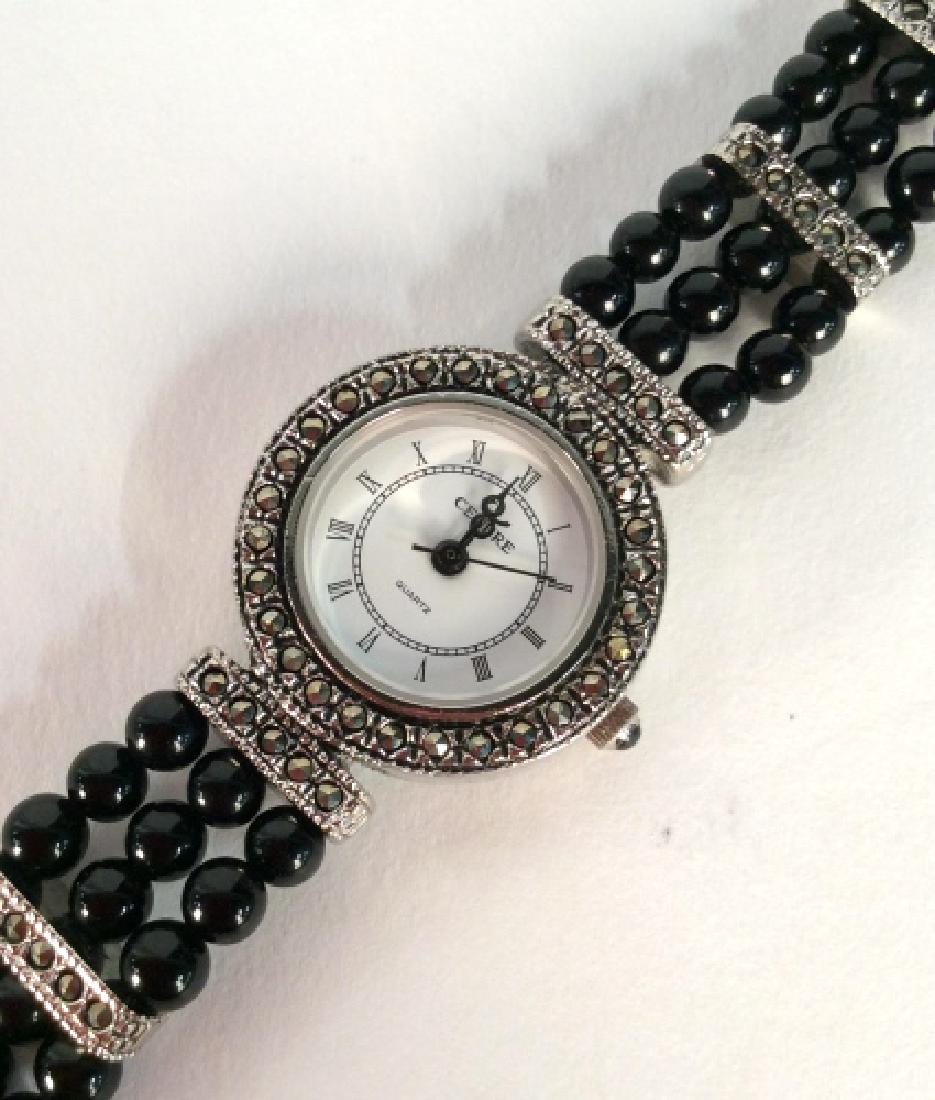 CENERE Ladies Wristwatch W Marcasite: CENERE Ladies Wristwatch W Marcasite And Black Toned Glass Beads, Silver Toned metal body, face framed with marcasite inlay, has not been tested. Measures approx 2 in in diameter, 7 in long when laid 