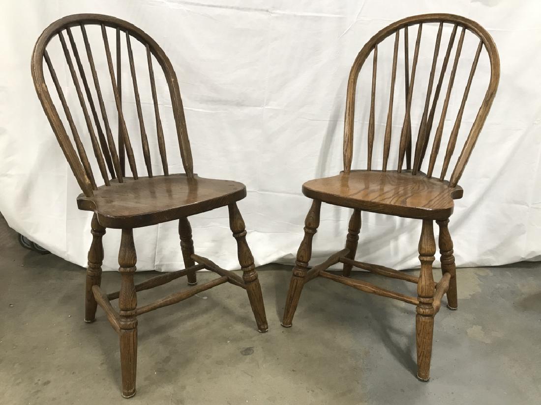 Pair Oak Toned Wooden Windsor Style Dining Chairs: Vintage Pair Oak Toned Wooden Windsor Style Dining Chairs. Some chips and surface wear to Chairs. Measures approx 36 inches tall x 19.5 inches deep x 18 inches wide. Wooden dining chairs. Windsor Dini