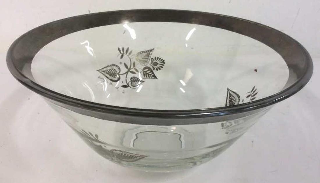 Glass Bowl W Silver Tone Rim & Floral Pattern: Glass bowl with silver tone rim. bowl has silver toned floral motifs. signed George, second name illegible. Some fading of silver tone on larger bowl. bowl is approximately 10 inches in diameter by 5