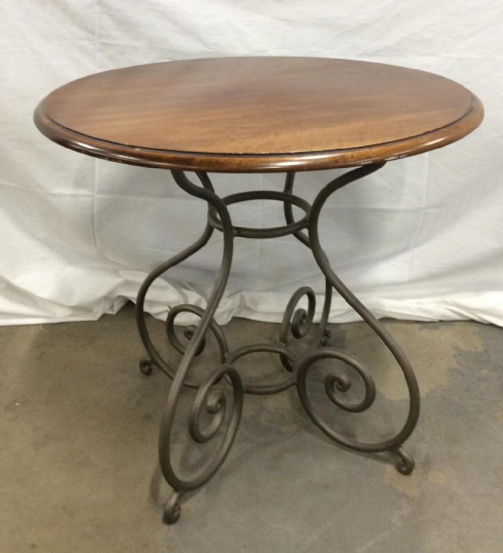 Wooden Pedestal Table W Curled Metal Base: Wooden Pedestal Table W Curled Metal Base. Round curricular tabletop with dark grey toned metal four legged curved motif base. Pedestal table, end table, side table, home furnishings, home accessory, 