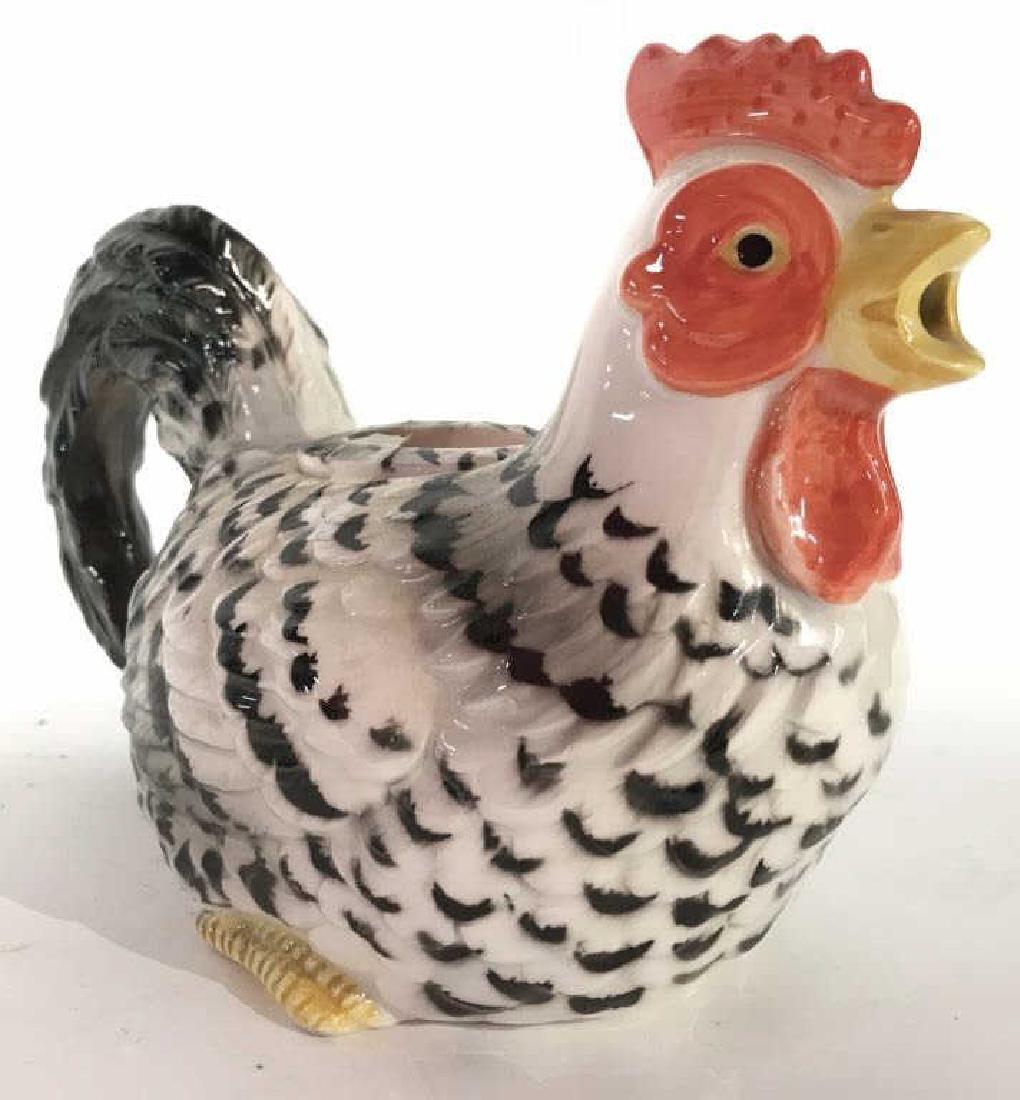 Porcelain Chicken Pitcher: Dish is in Shape of chicken contains tones of red white and black. Has hole in beak area for pouring. Has lid in middle. Measures approx 9 inches long 6 inches tall 4.5 inches wide. Tableware, serving