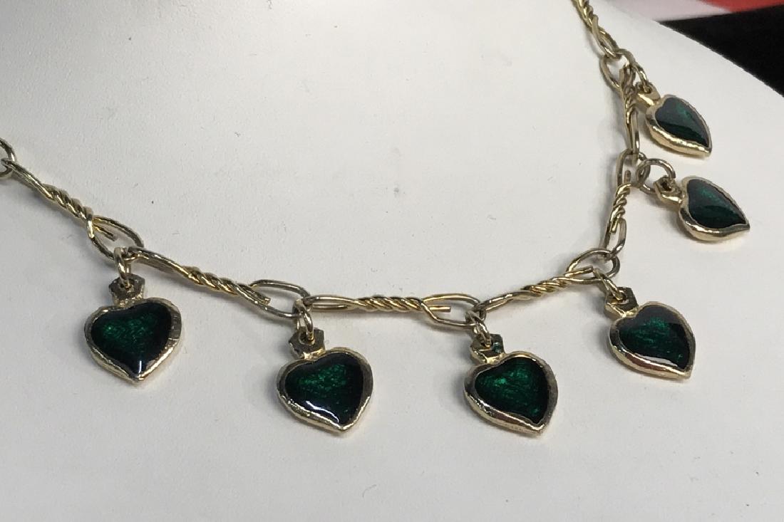 Gold Toned Heart Charm Necklace: Gold toned twist and loop chain with claw clasp, and six dangling heart charms, emerald toned centers to gold toned casings, hearts each measure app .75 inches, drop from clasp app 7.5 inches, estate