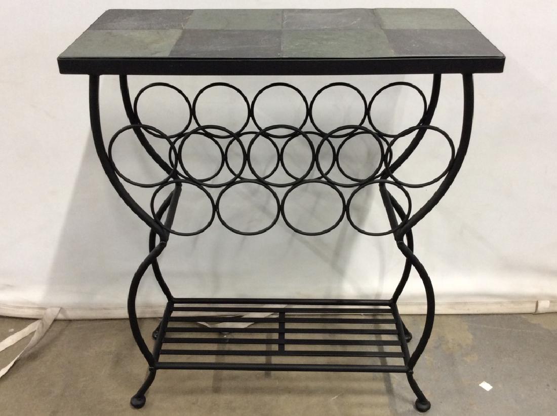 Metal Wine Rack Table: Wine rack table has 9 wine bottle spaces. Top of table is slate and green toned. Has 4 legs. Contains some minor wear. Measures approx 22 inches long 27 inches tall 10 inches deep. Home furnishings, h