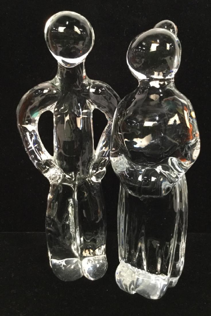 Pair Glass Sculpted Figurals: Pair Glass Sculpted Figurals, Glass Figurals Of man and woman, minimalist sculpture, decorative accessories, tabletop accessory, shelf piece, home decor, glass ware. Measures approx 8 in By 3 in. Prop
