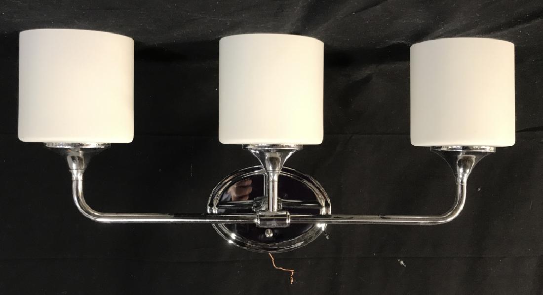 Lot 5 Chrome and Glass Bathroom Wall Sconces: Set of chrome and etched white glass shade bathroom wall sconces. Group includes 3 triple light wall sconces and two single bulb sconces. Sconces are specifically made for humid environments. Triple l