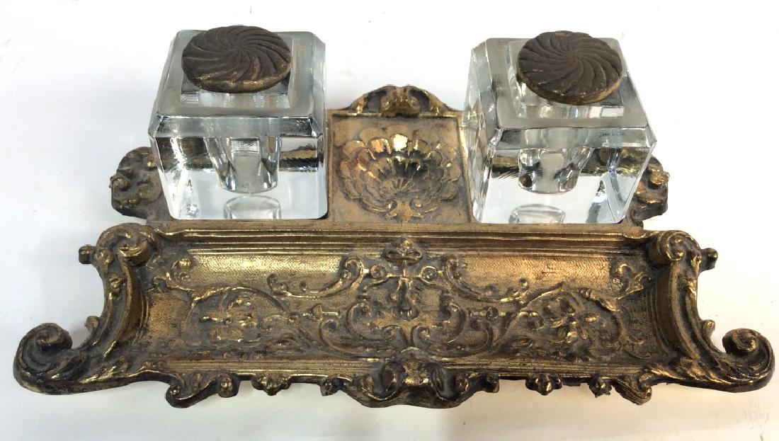 French Antique Style Brass And Glass inkwell Set: French Antique Style Brass And Glass inkwell Set, 11 in long x 7 in deep, one Inkwell has crack on base, ornate foliage Designs With curled edges of pen holder, inkwells with brass covers, not marked,