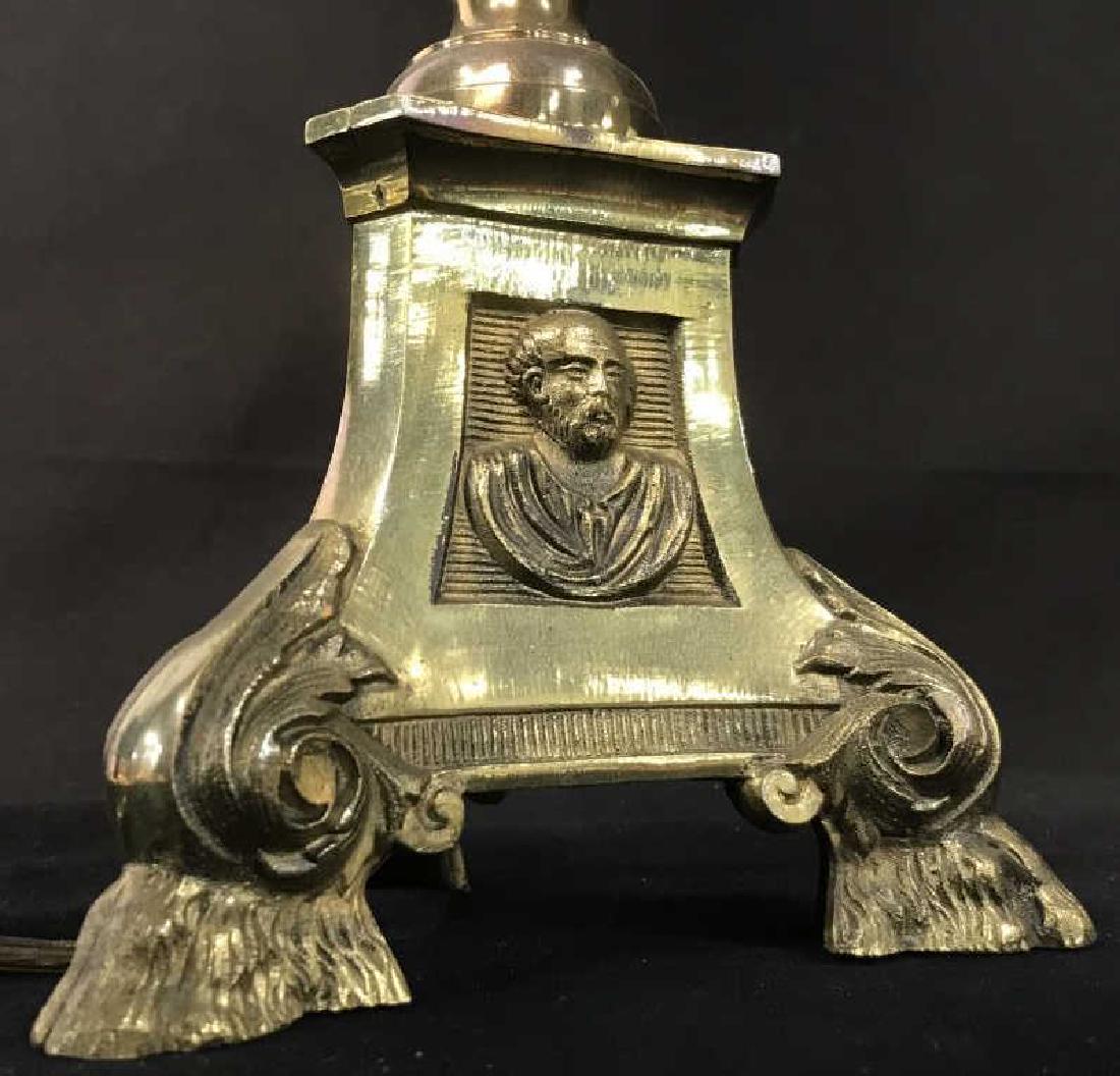 Brass Tone Mixed Metal Accent Table Lamp: Brass tone mixed metal table lamp. Lamp has three footed base with portrait emblems in relief. Lamp has not been tested, plug will need replacement. Approx 31 inches in height including harp, 5.5 inch