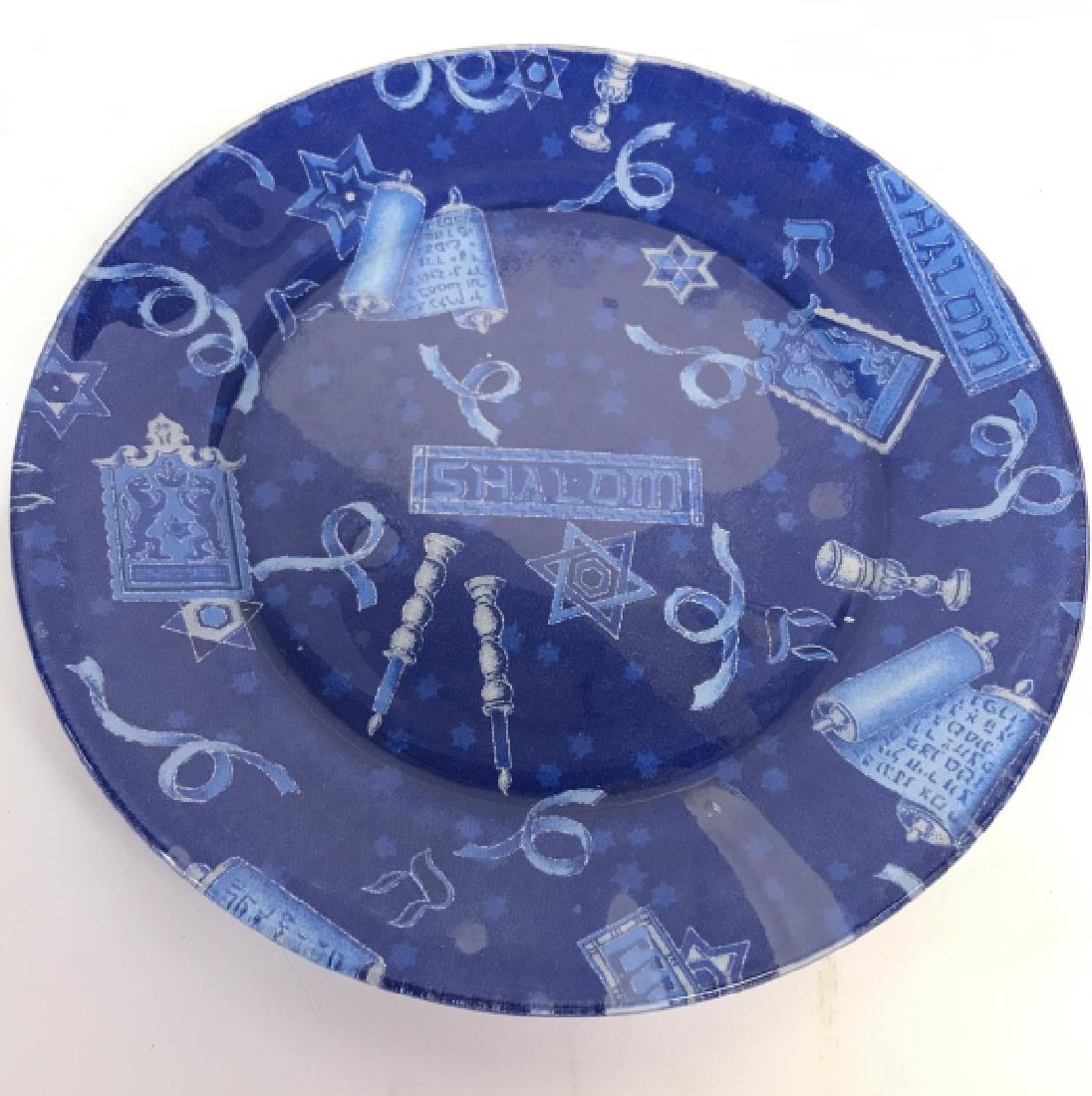Blue Toned Judaica Plate: Plate is glass & blue toned. Contains depictions of Torah’s, Candlesticks, & The Star Of David. Plate reads SHALOM in multiple areas. Measures approx 9 inches wide. Property of a Palm Beach Florida