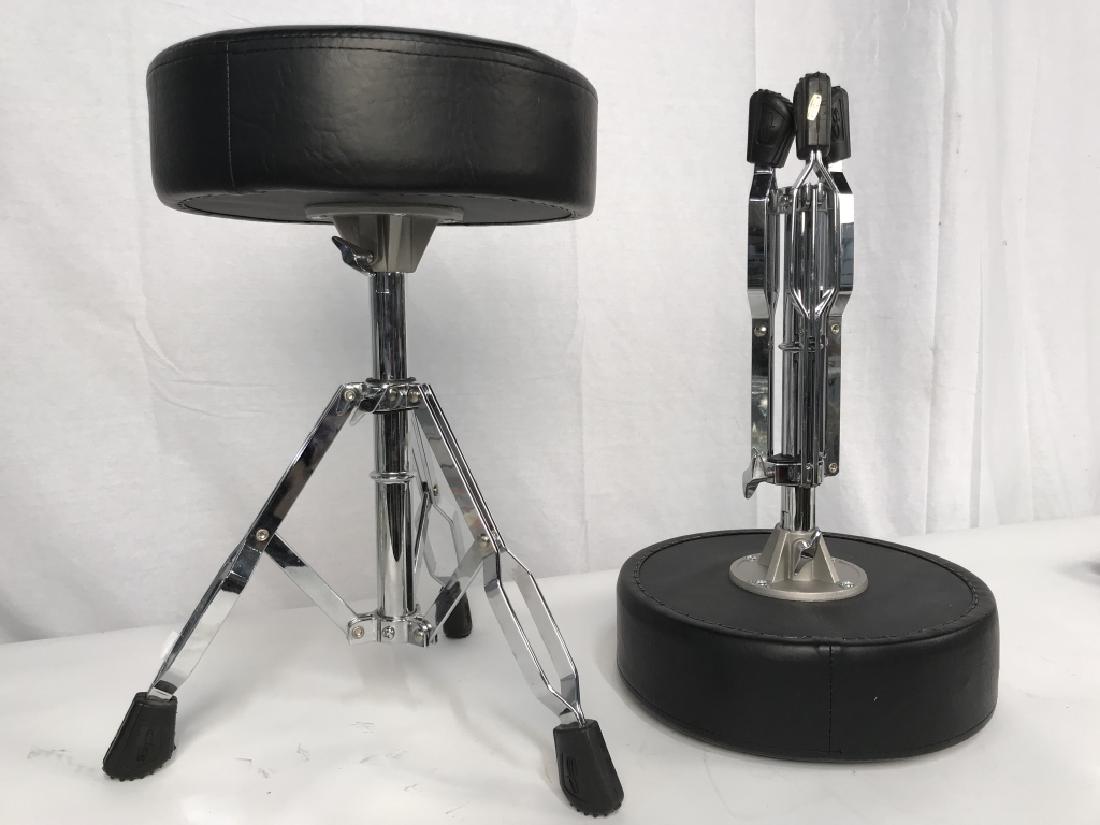Pair of Extendable Musician’s Stools: Pair of extendable musician’s stools. On-Stage Round Cushioned Drum Throne with Double-braced Legs. Each stool approx 19.5 inches in height by 12 inches in diameter. Black tone cushion seat with sil